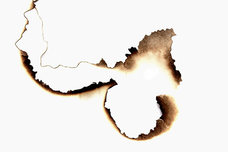 burnt holes in a paperの写真素材