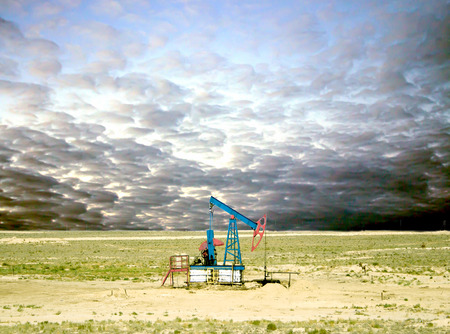 pumping oil from an oil well on the background of sky with cloudsの写真素材