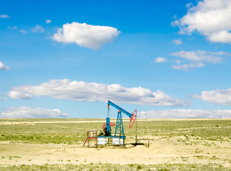 pumping oil from an oil well on the background of sky with cloudsの写真素材
