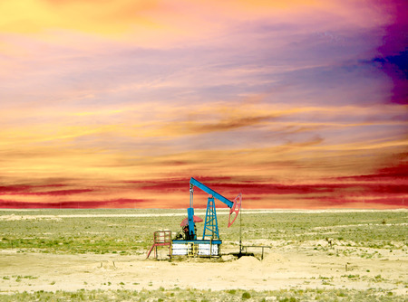 pumping oil from an oil well on the background of sky with cloudsの写真素材