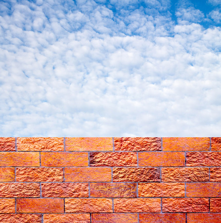 fence of decorative red brick wall against blue skyの写真素材