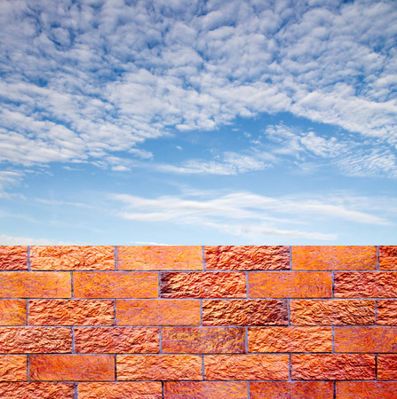 fence of decorative red brick wall against blue skyの写真素材