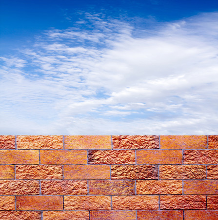 fence of decorative red brick wall against blue skyの写真素材