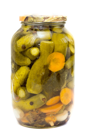 pickled cucumbers and carrots in a glass jar on white の写真素材