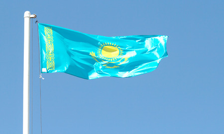 Kazakhstan waving flag against blue sky