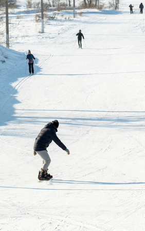 PETROPAVLOVSK, KAZAKHSTAN- JANUARY 31, 2016: Snowboard ride from the mountain in a forest in a recreation center in Kazakhstanのeditorial素材