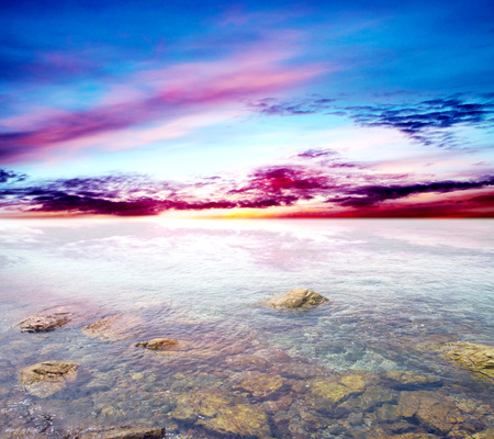 rocky entrance to the sea on a background of blue sky with cloudsの写真素材
