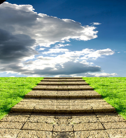 stone steps on the grass in the sky cloudsの写真素材