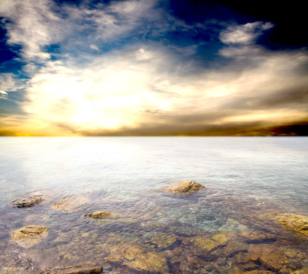rocky entrance to the sea on a background of blue sky with cloudsの写真素材