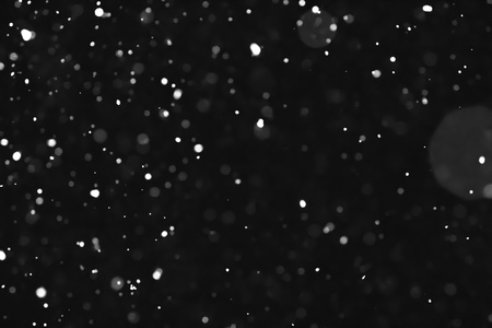Bokeh lights on black background, shot of flying snowflakes in the airの写真素材
