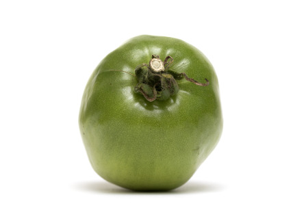 unripe green tomato on white backgroundの写真素材
