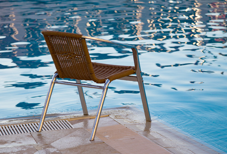 wicker chair beside a pool.の写真素材