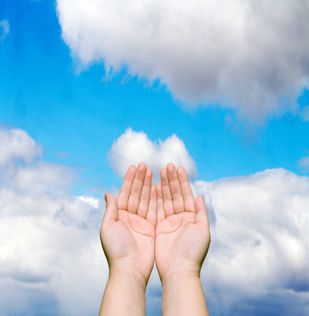 two human hands against the blue skyの写真素材