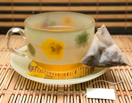 bowl with tea saucer with tea bagの写真素材