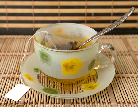 bowl with tea saucer with tea bagの写真素材