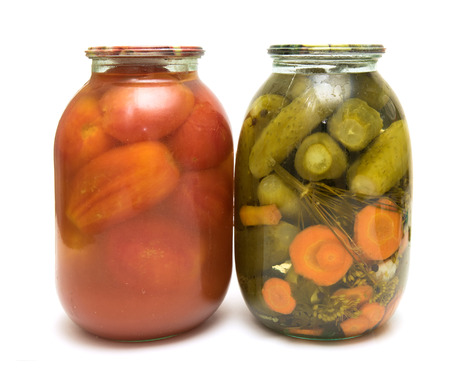 glass jar with cucumbers and tomatoes on a white backgroundの写真素材