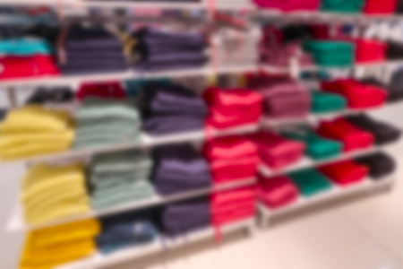 The clothes on the shelves in the store are blurry for the backgroundの写真素材