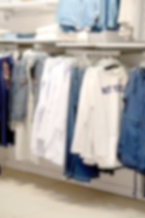The clothes on the shelves in the store are blurry for the background