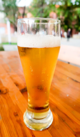 A glass of beer on the table in a summer cafe