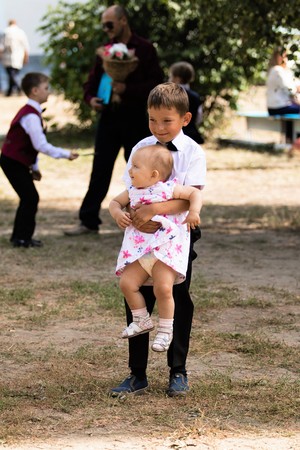 Petropavlovsk, Kazakhstan - September 2, 2017: School line is in schoolyard with pupils and teachers. Children go back to school. The Knowledge Day in Kazakhstan first day of school.のeditorial素材