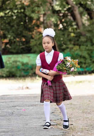 Petropavlovsk, Kazakhstan - September 2, 2017: School line is in schoolyard with pupils and teachers. Children go back to school. The Knowledge Day in Kazakhstan first day of school.のeditorial素材