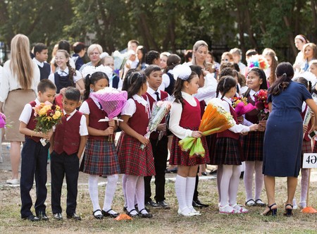 Petropavlovsk, Kazakhstan - September 2, 2017: School line is in schoolyard with pupils and teachers. Children go back to school. The Knowledge Day in Kazakhstan first day of school.のeditorial素材
