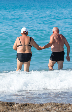 man and woman on the beach in swimsuit, rear viewの写真素材