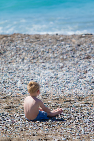 little boy by the sea on the beachの写真素材