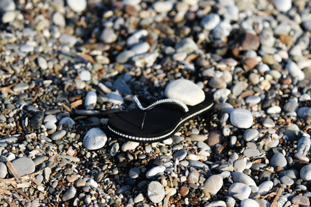 rubber shoes on the beach pebblesの写真素材