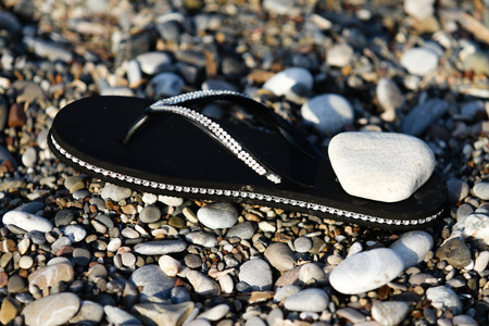 rubber shoes on the beach pebblesの写真素材