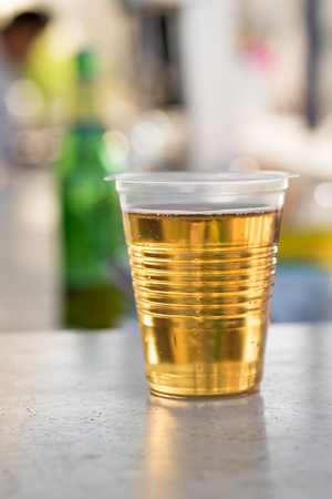 beer in a plastic glass on the tableの写真素材