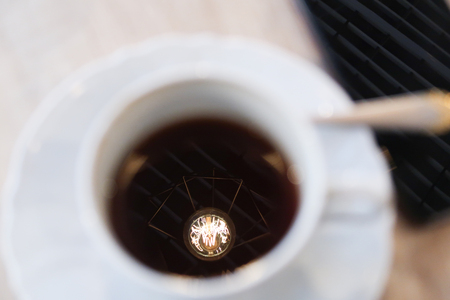 cup of coffee on a table lamp lightingの写真素材
