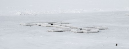 cross on the ice in winterの写真素材