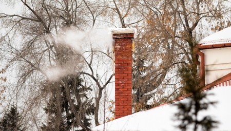 smoke from the chimney of the house winter pipe of red brickの写真素材