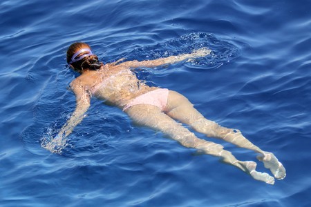 girls swim in the sea with a mask