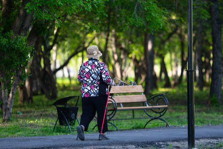 an elderly woman walks in the parkの写真素材