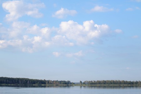 sky clouds lake forest village in the distanceの写真素材