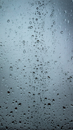 drops of rain on the glass, the view on the street is blurred