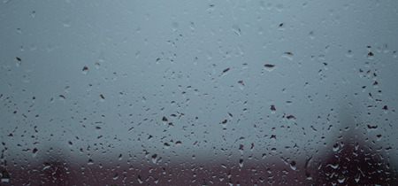 drops of rain on the glass, the view on the street is blurredの写真素材