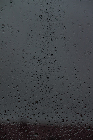 drops of rain on the glass, the view on the street is blurredの写真素材