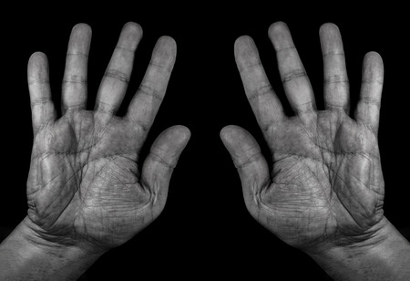 male hands and fingers close up on black background, black photo