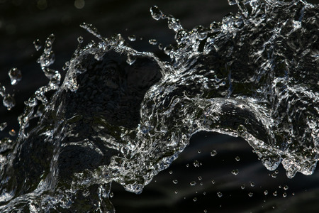 water drops in the air on a dark bokeh backgroundの写真素材