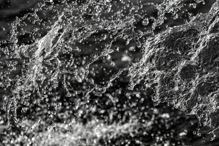 water drops in the air on a dark bokeh backgroundの写真素材