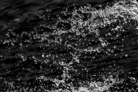 water drops in the air on a dark bokeh backgroundの写真素材