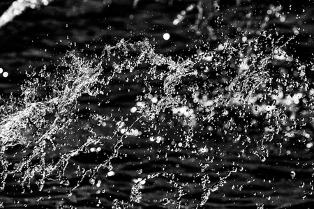water drops in the air on a dark bokeh backgroundの写真素材