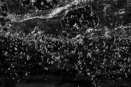 water drops in the air on a dark bokeh backgroundの写真素材