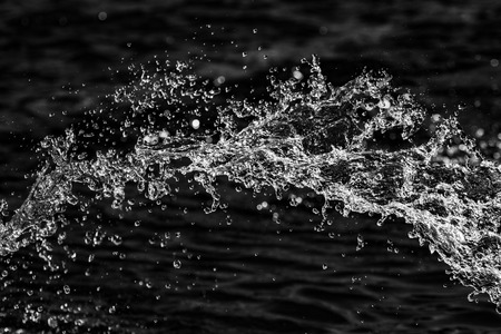 water drops in the air on a dark bokeh backgroundの写真素材