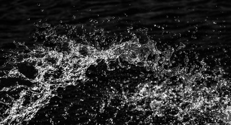 water drops in the air on a dark bokeh background