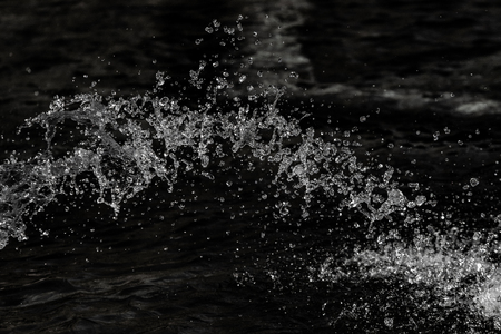 water drops in the air on a dark bokeh backgroundの写真素材