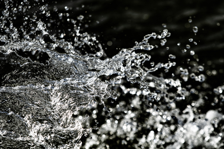 water drops in the air on a dark bokeh backgroundの写真素材